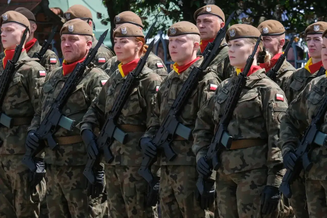 Żołnierze w mundurach i beretach, z karabinami w rękach, gotowi do służby. Marzysz, jak wstąpić do wojska? To pierwszy krok.