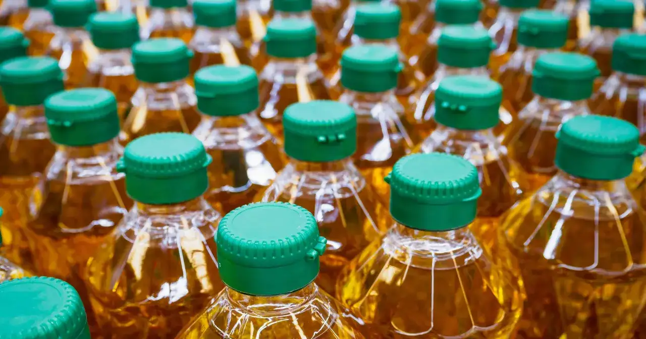 Wiele butelek oleju roślinnego z zielonymi nakrętkami.