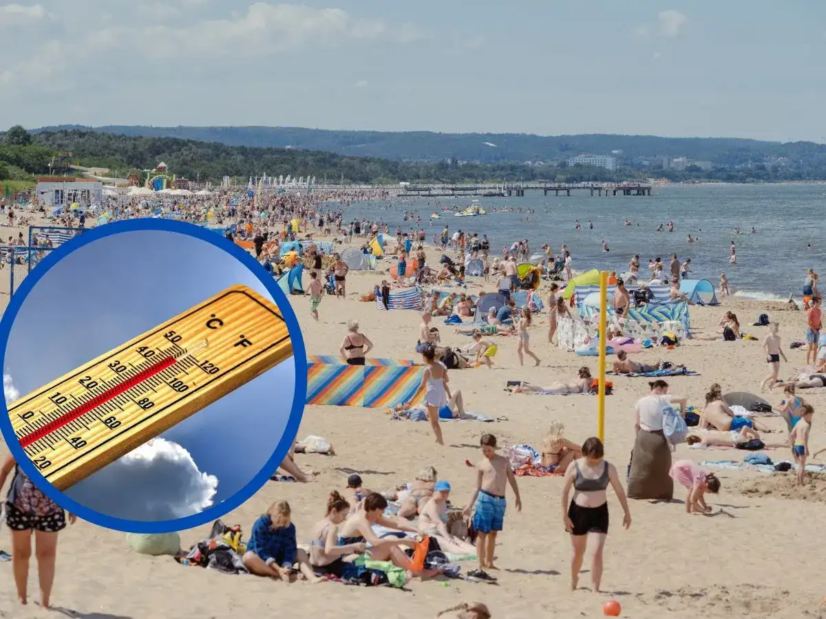 Termometr w okręgu na tle plaży z ludźmi i morzem.