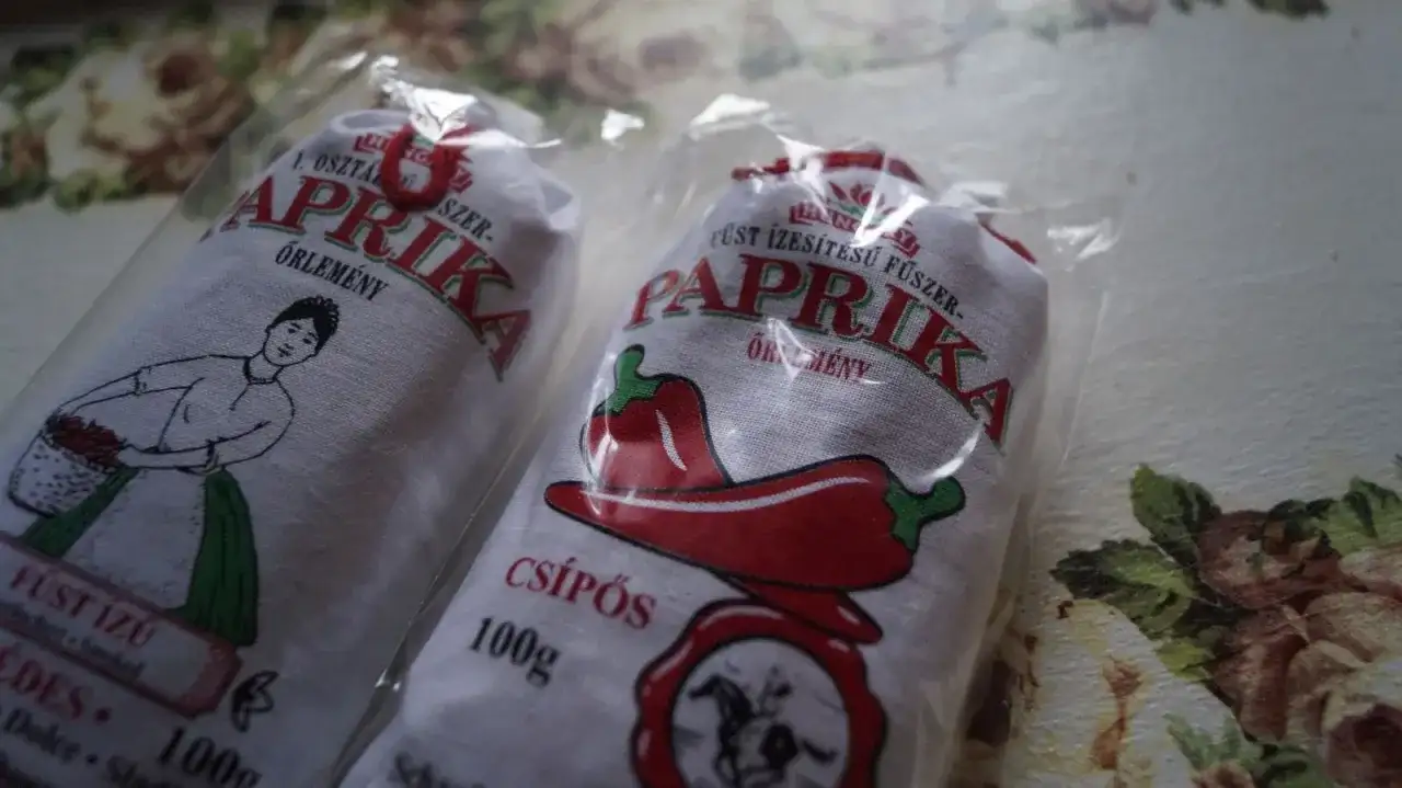Dwie paczki mielonej papryki z Węgier, jedna z rysunkiem kobiety z koszykiem, druga z papryczką.