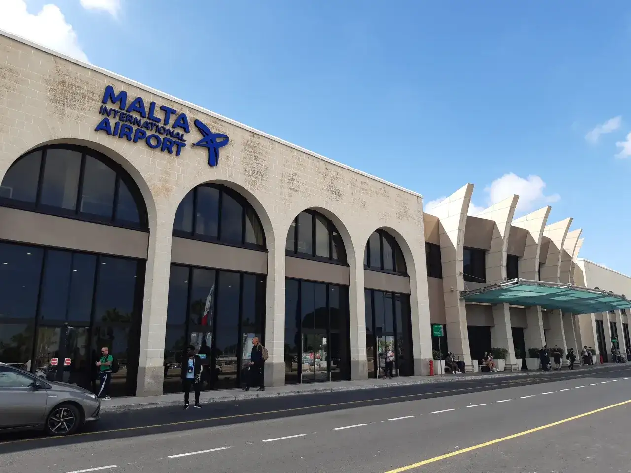 Elegancki budynek portu lotniczego Malta z łukowymi oknami i nowoczesnymi elementami architektonicznymi.