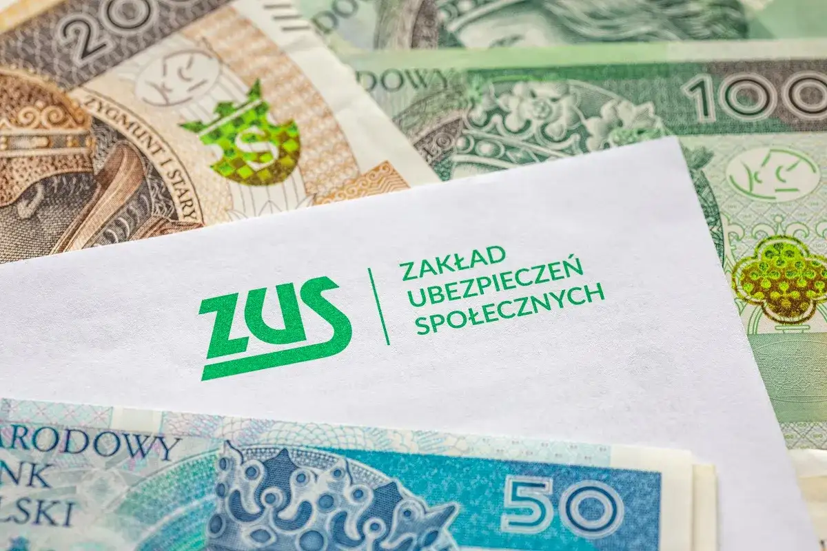 Koperta z logo ZUS na tle polskich banknotów. Symbolizuje opłacanie składek ZUS samemu, co jest ważnym elementem finansowej przyszłości.