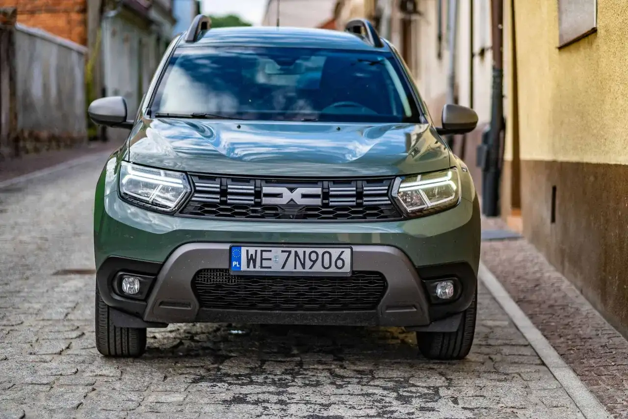 Zielony Dacia Duster na brukowanej uliczce. Sprawdź, jakie jest dacia duster spalanie i wybierz się na przygodę.