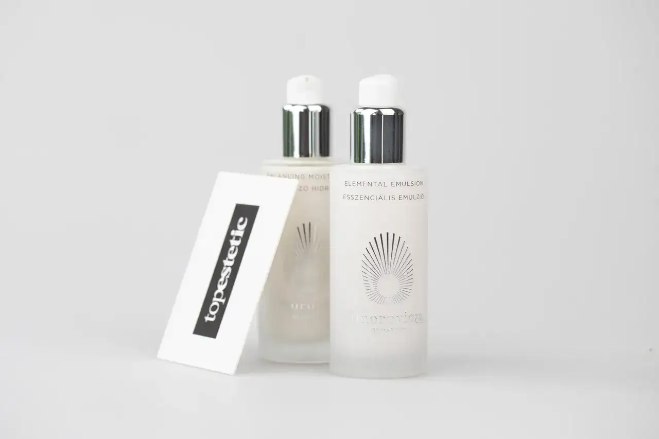 Szukasz pomysłu, co kupić na Węgrzech? Kosmetyki Omorovicza to luksusowy wybór. Dwie buteleczki emulsji na białym tle.