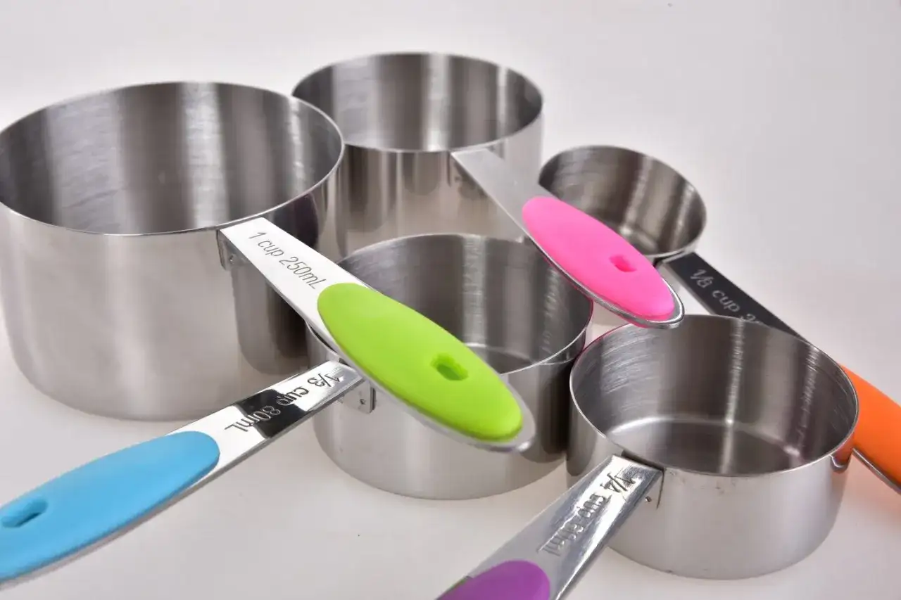 Zestaw metalowych miarek kuchennych z kolorowymi uchwytami.
