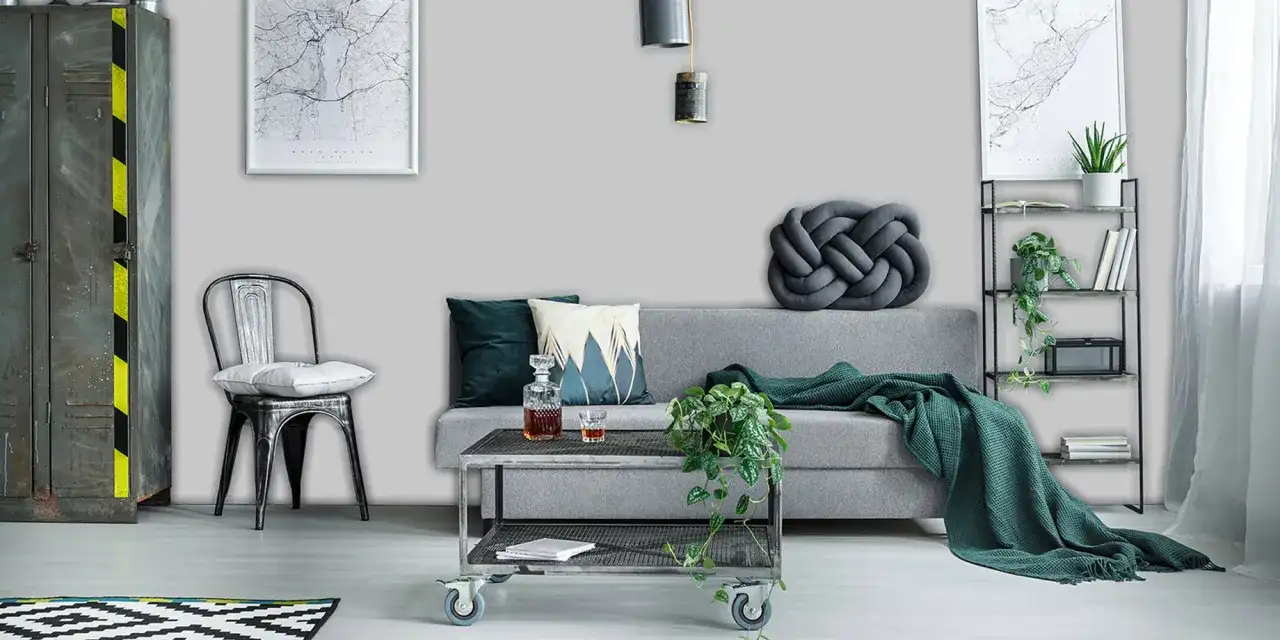 Nowoczesny salon z szarą sofą, metalowym fotelem i stolikiem. W tle industrialna szafa i regał. Kolory kojarzą się z szarym pirytem lub srebrzystym granitem.