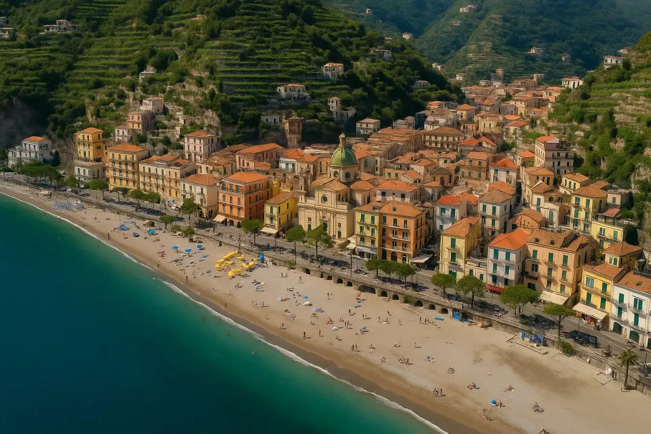 Malownicze wybrzeże, gdzie kręcono bez litości 3. Kolorowe domy wznoszą się na zboczu, a plaża tętni życiem.