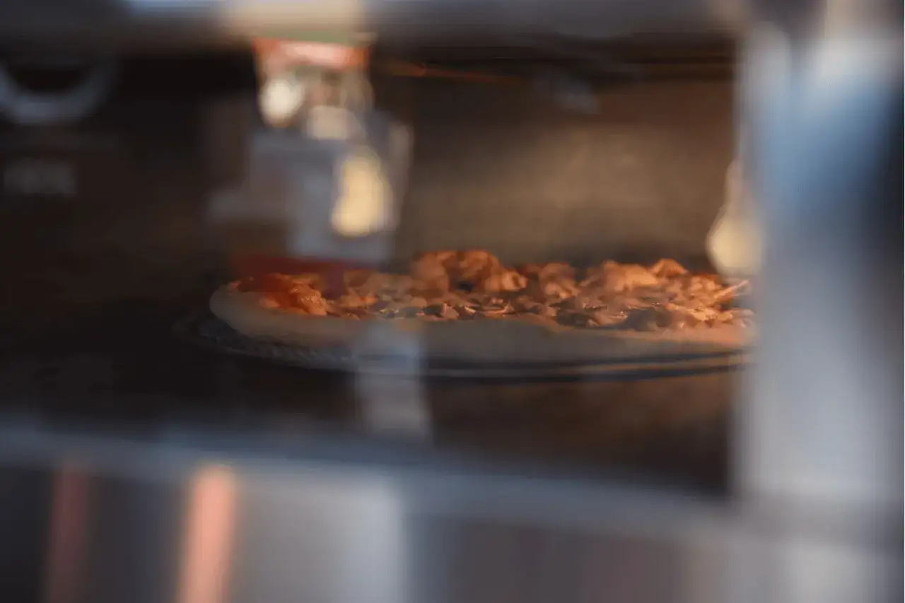 Pizza piecze się w wysokiej temperaturze, by uzyskać chrupiący spód i idealnie roztopiony ser.