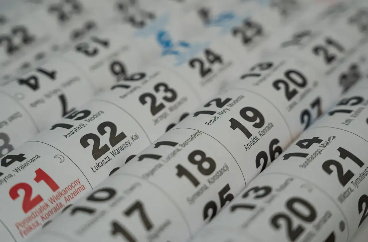 Zbliżenie na kalendarz z zaznaczonymi datami i imionami.