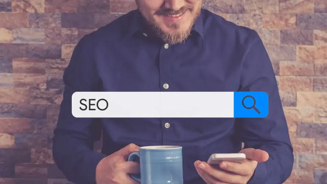 Mężczyzna z kubkiem kawy i telefonem szuka w internecie informacji o SEO. W pasku wyszukiwania widnieje hasło "SEO", sugerujące poszukiwanie w katalogu stron.
