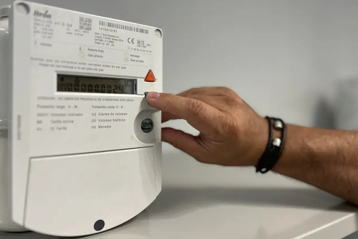 Mano interactuando con un contador digital de gas.