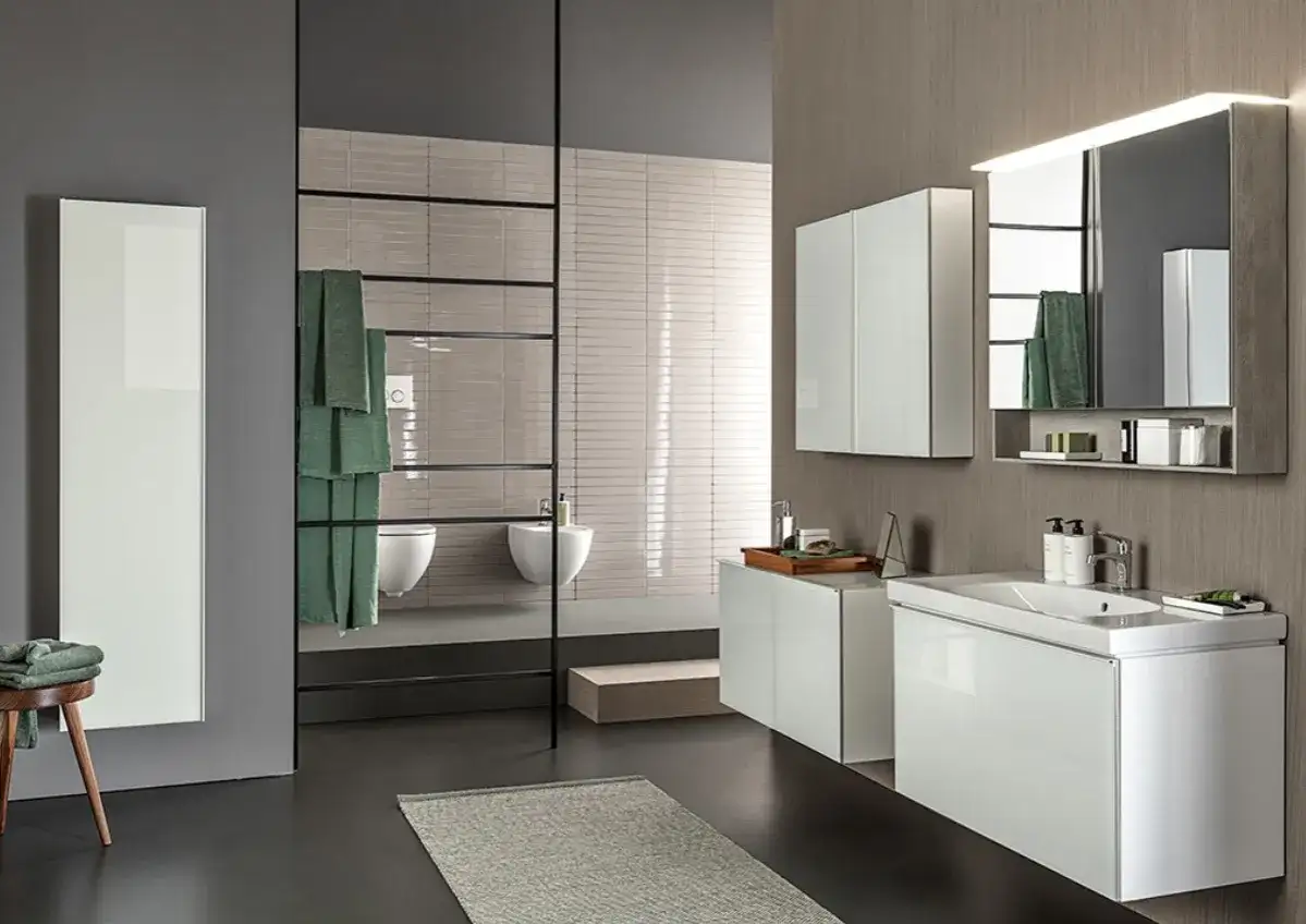 Nowoczesna łazienka z białymi meblami, lustrem, toaletą i bidetem.