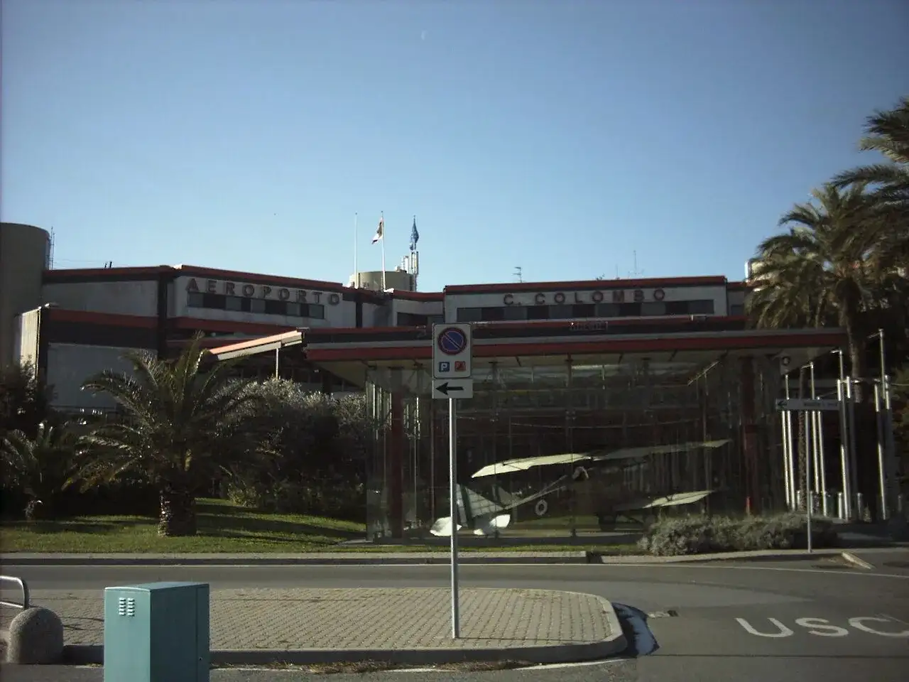 Port lotniczy Genua C. Colombo. W szklanej gablocie stoi zabytkowy samolot.