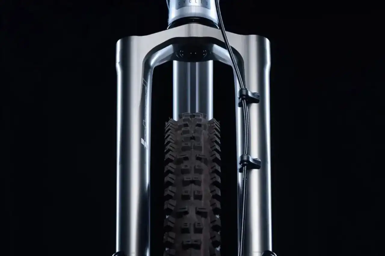 Przednia amortyzowana piasta rowerowa z oponą na czarnym tle.