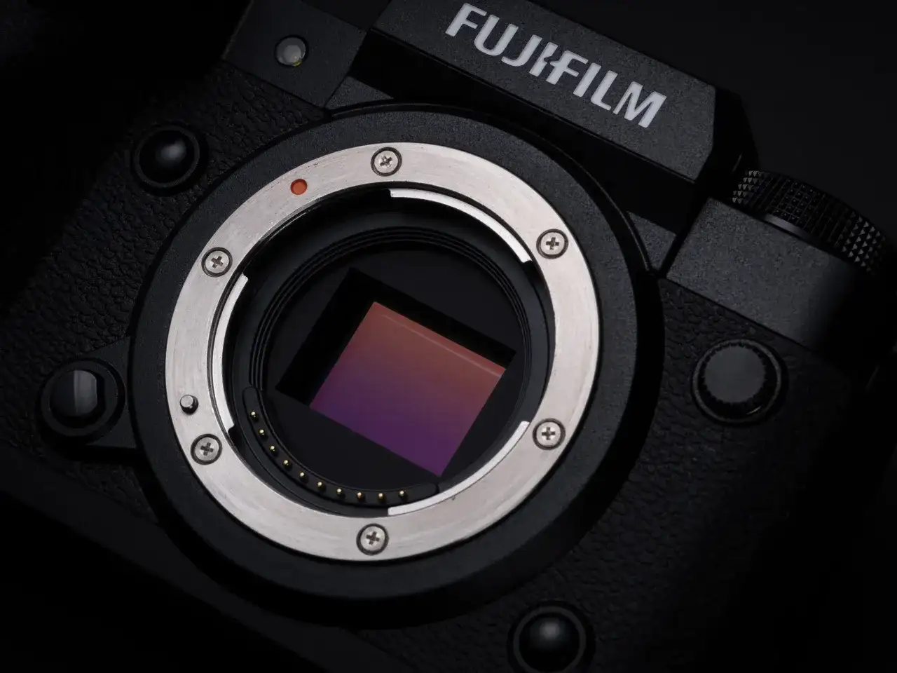Zbliżenie na sensor aparatu Fujifilm XH2S. Widoczny metalowy pierścień mocowania obiektywu i złote styki.