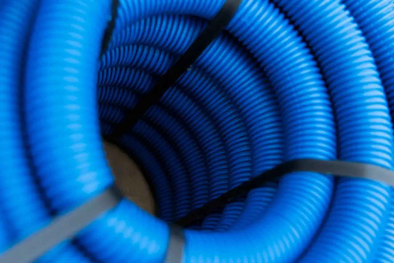 Zwijający się w spiralę, niebieski peszel, z czarną taśmą spinającą. Widać jego karbowaną strukturę.