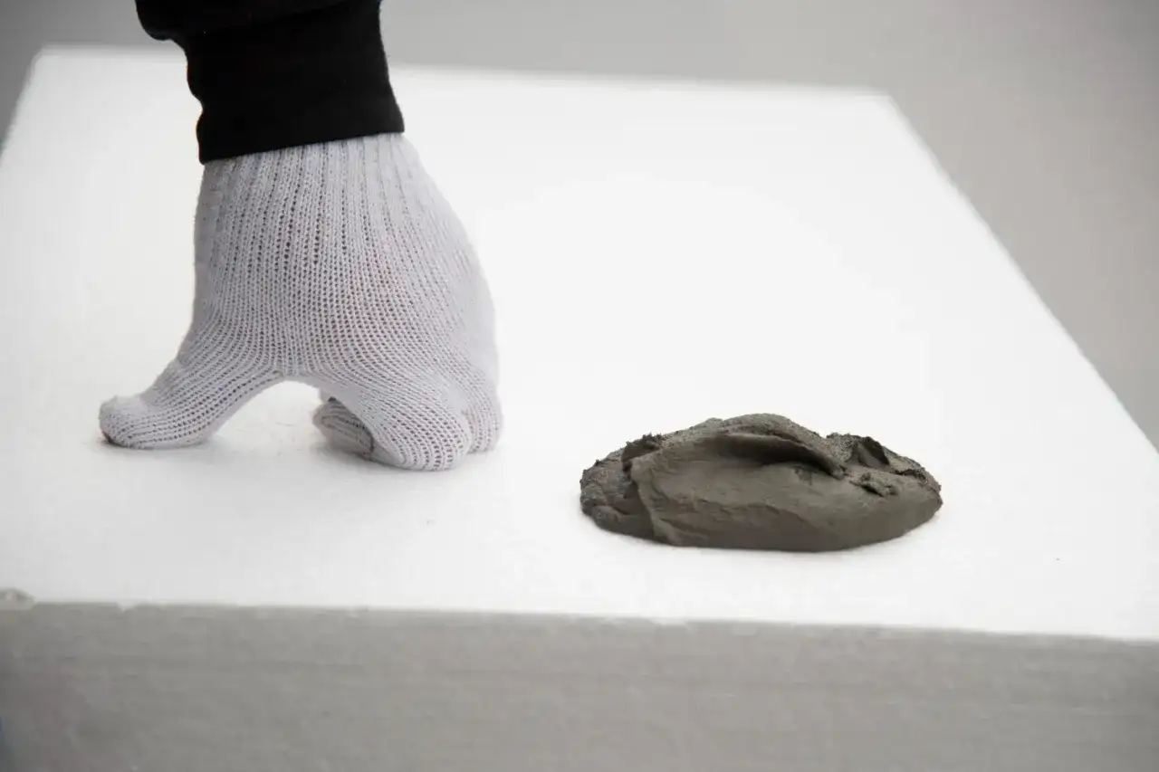 Rękawica na białym styropianie, obok masa szpachlowa. Idealny styropian na podłogę pod wylewkę.