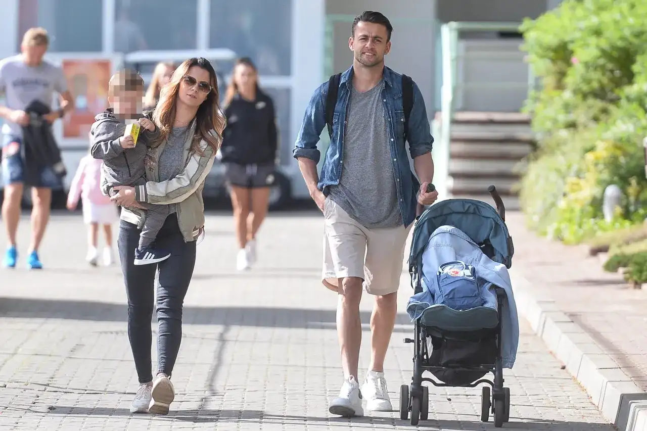 Para spacerowa: kobieta z dzieckiem na rękach i mężczyzna pchający wózek. Czy Fabiański ma dzieci? Tak, wygląda na to, że tak.