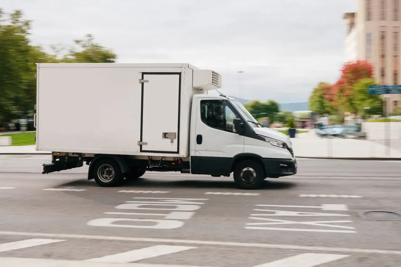 Biała chłodnia na drodze. Zastanawiasz się, czy warto mieć prawo jazdy C1? Ten pojazd to dobry przykład, do czego może być potrzebne.