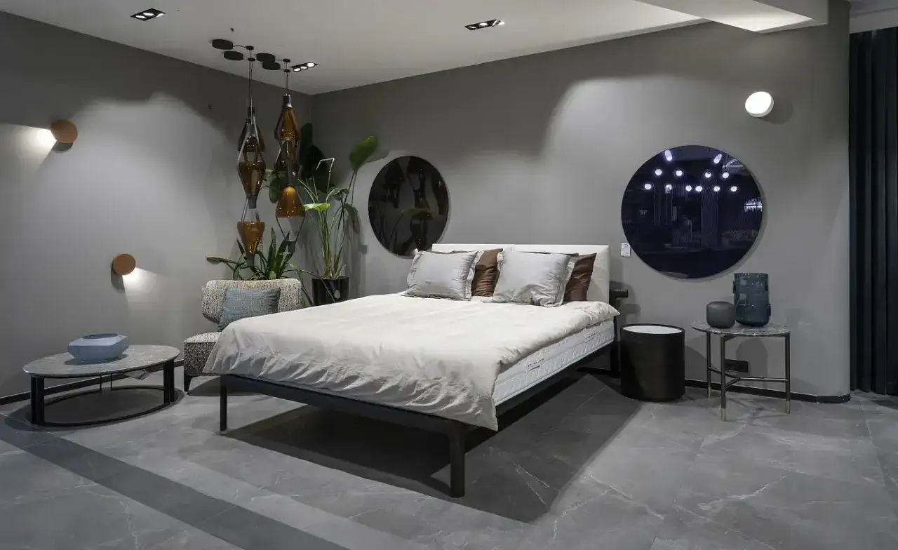 Nowoczesna sypialnia z kinkietami, łóżkiem i designerskimi dodatkami.