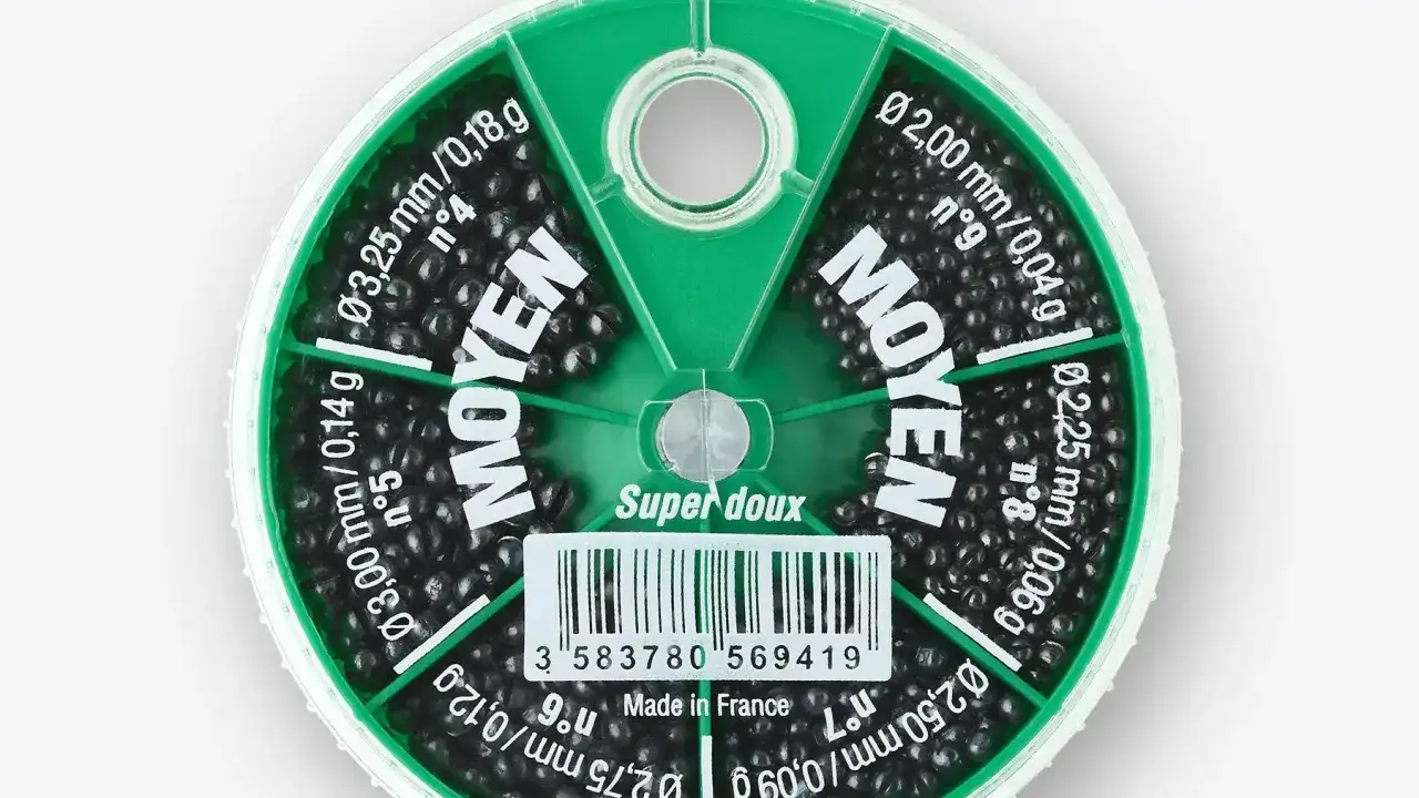 Pudełko z czarnymi śrutami wędkarskimi o różnych średnicach i wagach.