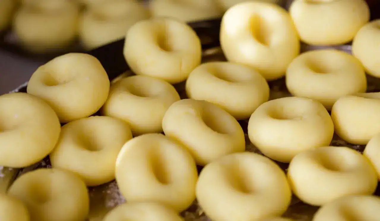 Surowe kluski śląskie ułożone na tacy, gotowe do mrożenia.