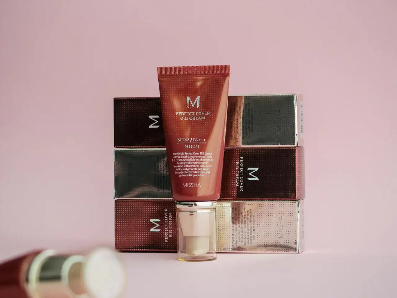 Krem BB Missha Perfect Cover nr 21 w tubce i pudełkach na różowym tle.