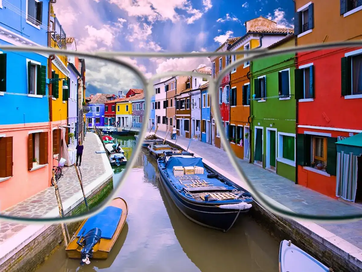 Okulary dla daltonistów pokazujące kolorowy kanał z łodziami i budynkami.