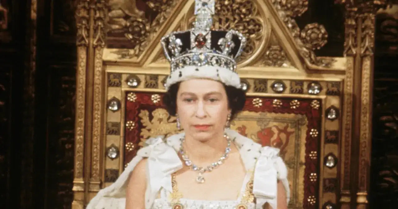 Królowa Elżbieta II w koronie i szacie, siedząca na tronie. Zastanawiamy się, ile żyła królowa Elżbieta, która panowała przez dekady.