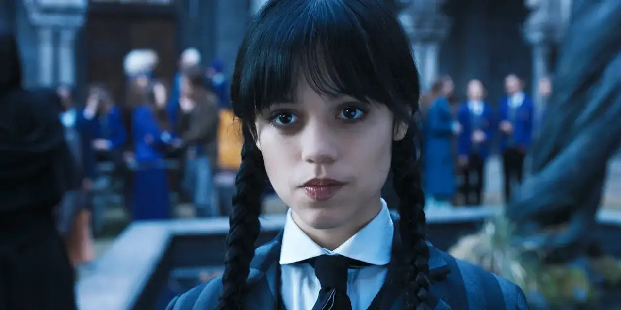 Wednesday Addams w okularach i krawacie, z niecierpliwością czekająca na drugi sezon.