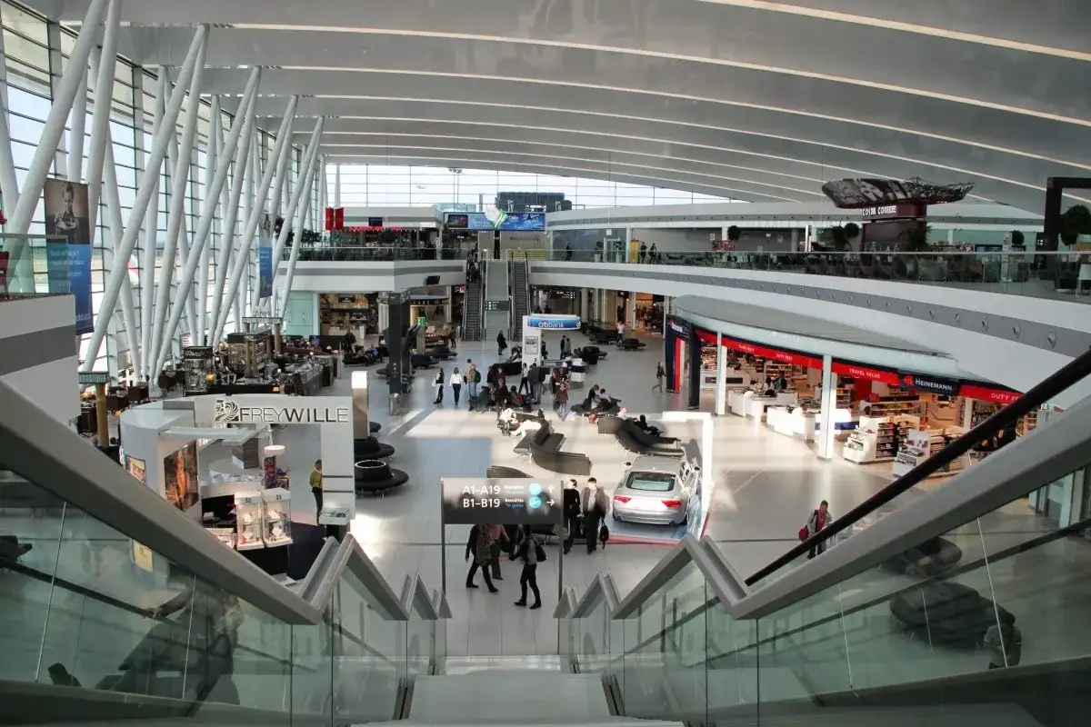 Nowoczesny terminal lotnisko Budapeszt im. Ferenca Liszta z licznymi sklepami i pasażerami.