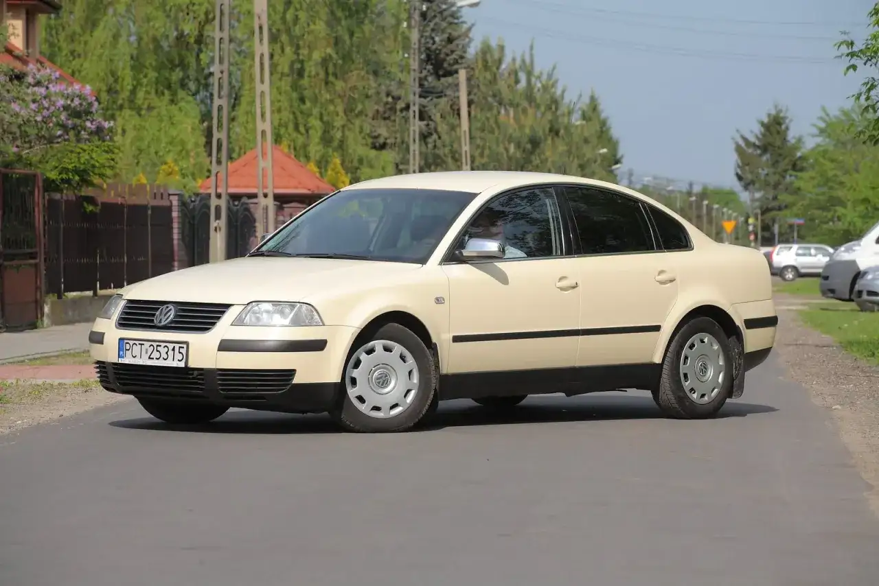 Jasny beżowy Volkswagen Passat B5 sedan na drodze.