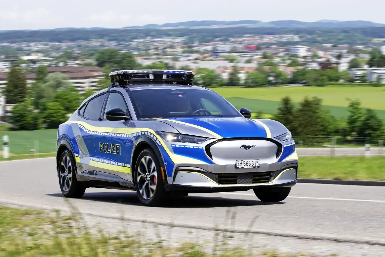 Policyjny Ford Mustang Mach-E z włączonymi sygnałami świetlnymi. Pamiętaj, kiedy można wyprzedzać pojazd uprzywilejowany.