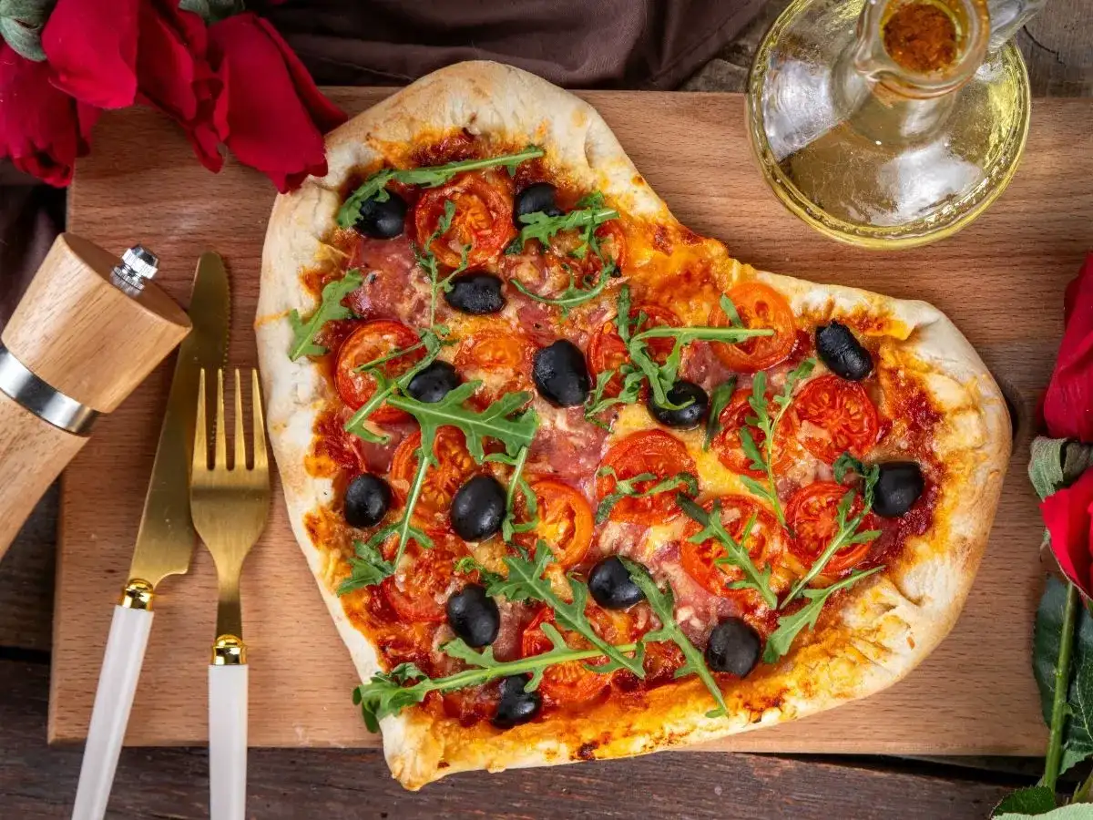 Pizza w kształcie serca z pomidorami, oliwkami i rukolą. Idealna na romantyczną kolację w domu, co ugotować?