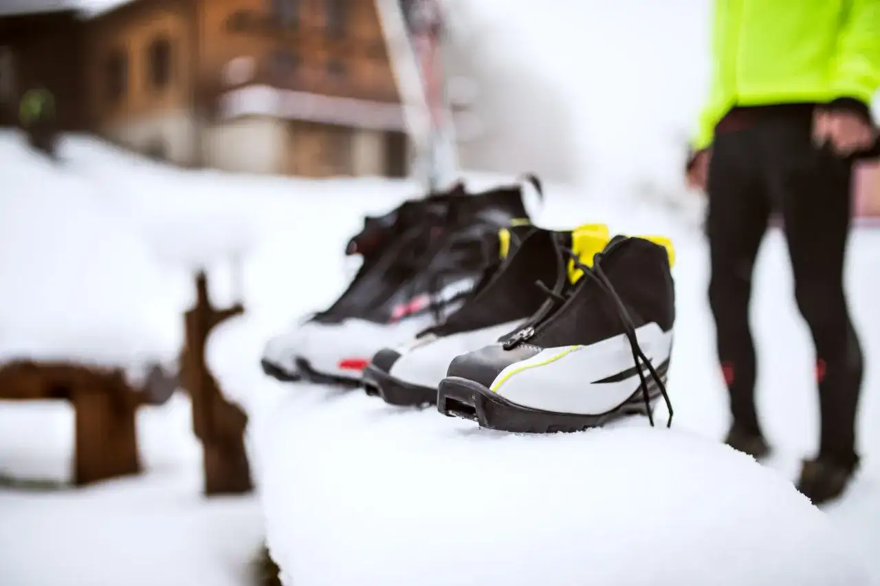 Buty narciarskie w śniegu. Zastanawiasz się, jak prać buty narciarskie? Oto one, gotowe do czyszczenia po dniu na stoku.