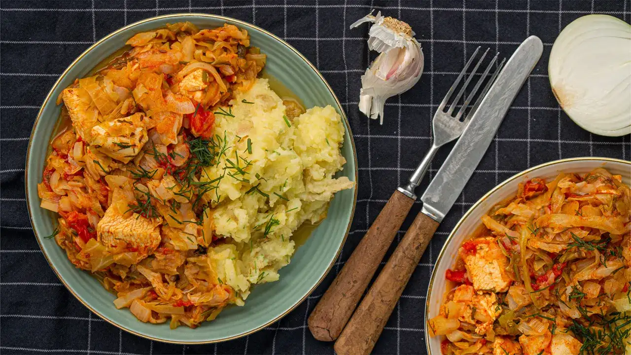 Pyszny bigos z kiszonej kapusty i mięsa, podany z ziemniakami. Zastanawiasz się, ile kalorii ma bigos z kiszonej kapusty?