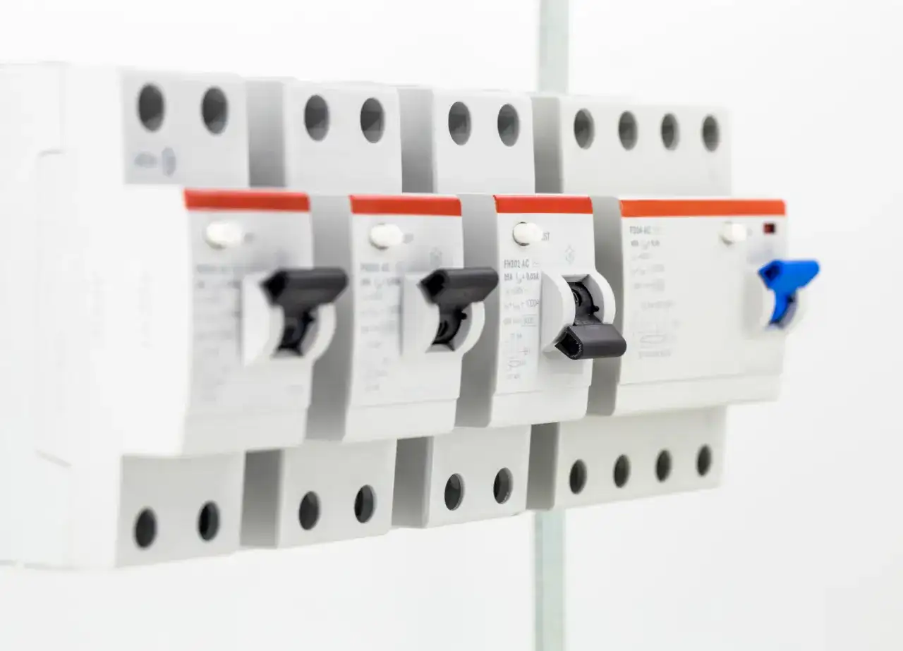 Szukasz informacji, jaki bezpiecznik do 5kW? Na zdjęciu widać rzędy wyłączników nadprądowych, które chronią instalację elektryczną.