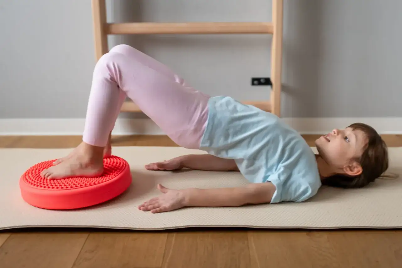 Dziecko ćwiczy na poduszce sensorycznej dla dzieci z ADHD, poprawiając równowagę i koordynację.