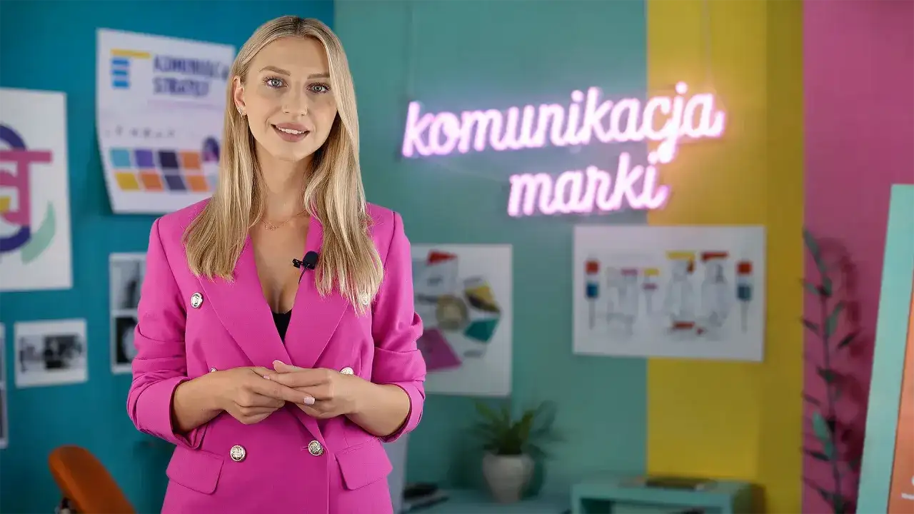 Kobieta w różowej marynarce wyjaśnia, jak przygotować się do pracy w branży marketingowej. W tle neon "komunikacja marki".