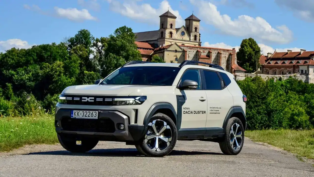 Nowa Dacia Duster hybryda na tle zabytkowego klasztoru.
