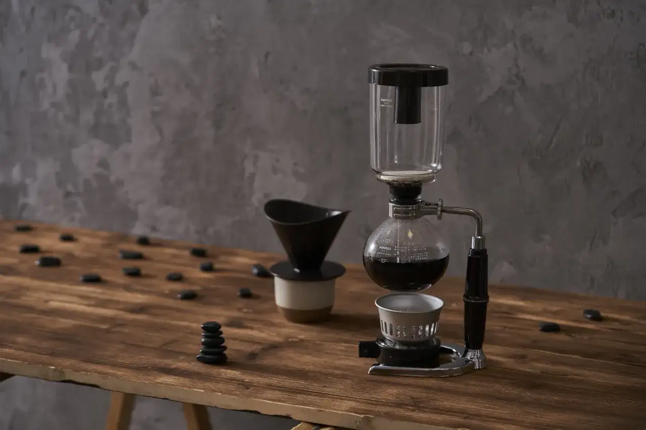 Kawiarka syfonowa i dripper na drewnianym blacie. Dowiedz się, jak długo parzyć kawę sypaną, by uzyskać idealny smak.
