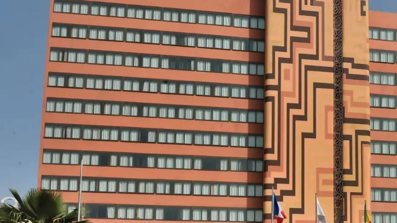 Façade d'un hôtel orange avec des motifs géométriques et des fenêtres.