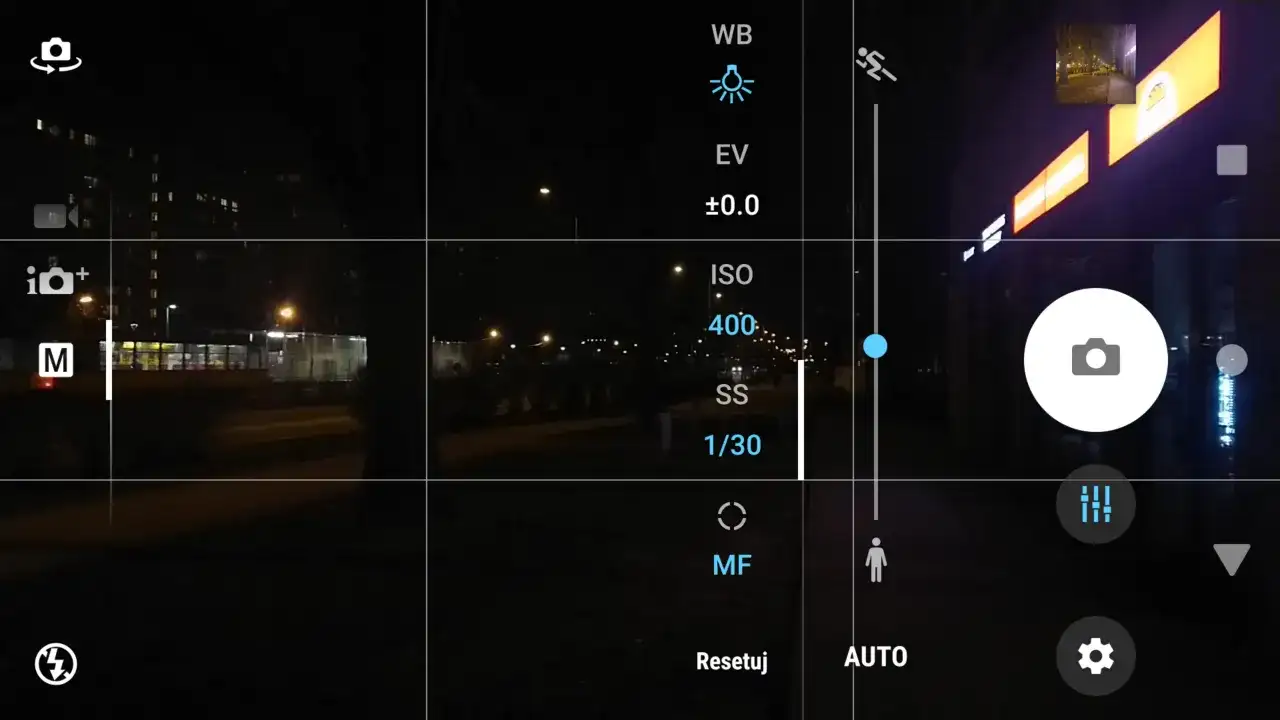 Ekran telefonu z widokiem nocnym. Ustawienia aparatu pokazują, jak ustawić długi czas naświetlania. Widoczny tryb manualny (M) i czas 1/30s.