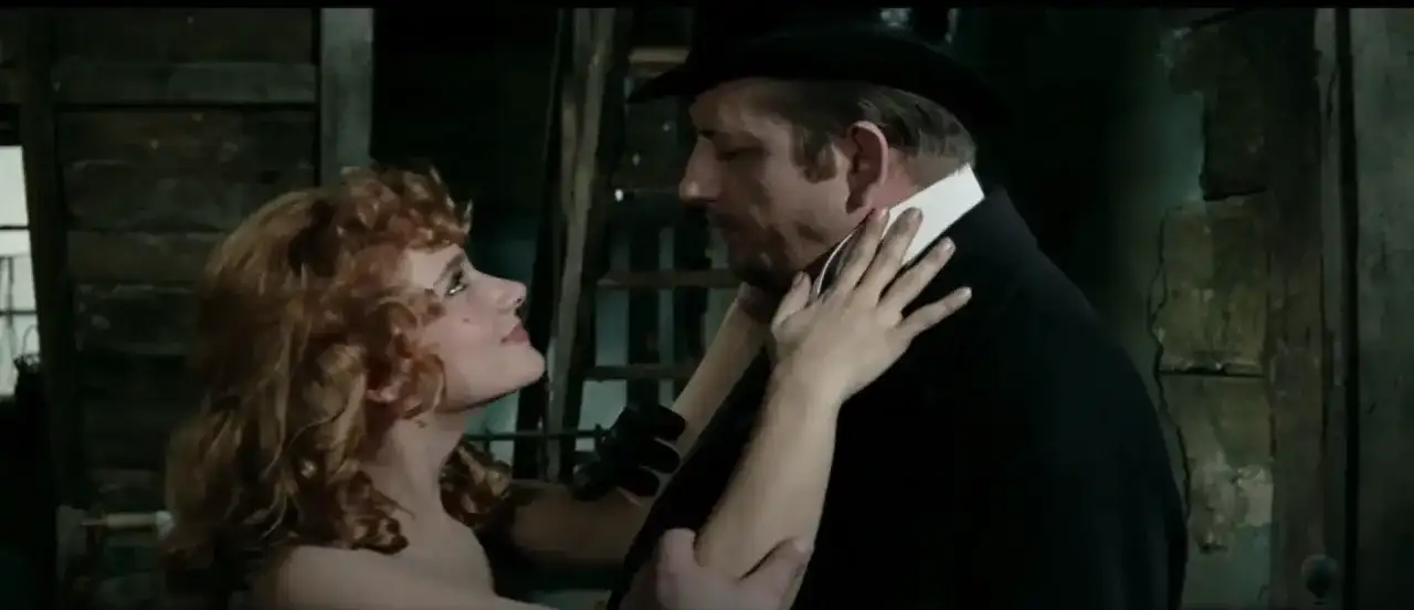 Kobieta z rudymi włosami patrzy na mężczyznę w czarnym kapeluszu i płaszczu. Scena z filmu Wojciecha Jerzego Hasa.