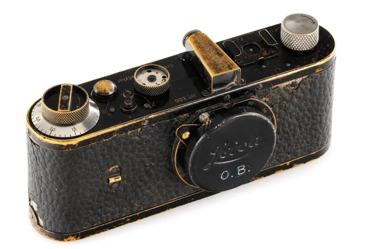 Antyczny aparat Leica, prawdopodobnie najdroższy aparat fotograficzny na świecie, z widocznym napisem "O.B." i złotymi detalami.