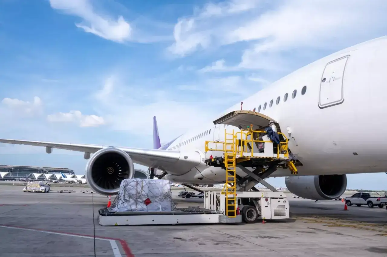 Ładunek, w tym mięso, jest ładowany do samolotu cargo. Pytanie, czy można przewozić mięso samolotem, jest tu kluczowe.