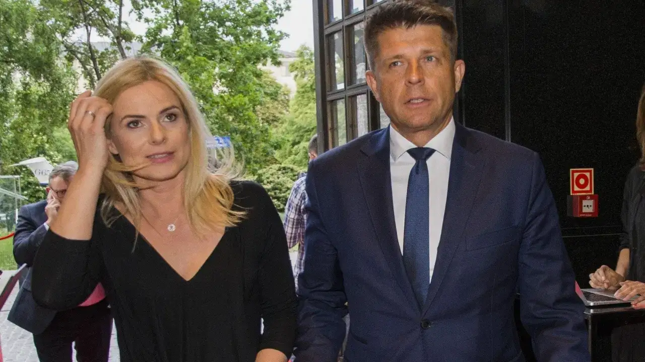 Para, która może być odpowiedzią na pytanie, czy Ryszard Petru ma żonę, idzie obok siebie. Kobieta ma blond włosy i czarną bluzkę, mężczyzna w granatowym garniturze.