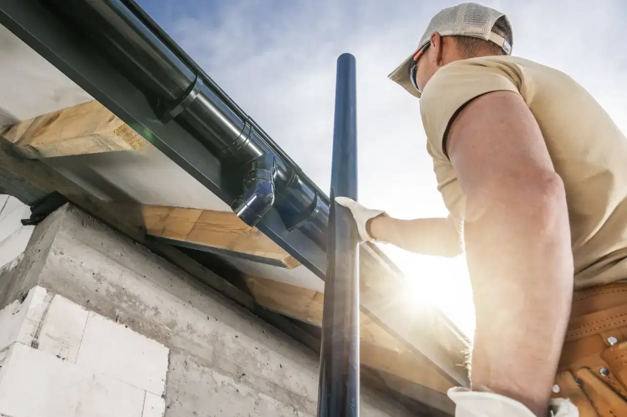 mężczyzna montujący system rynnowy