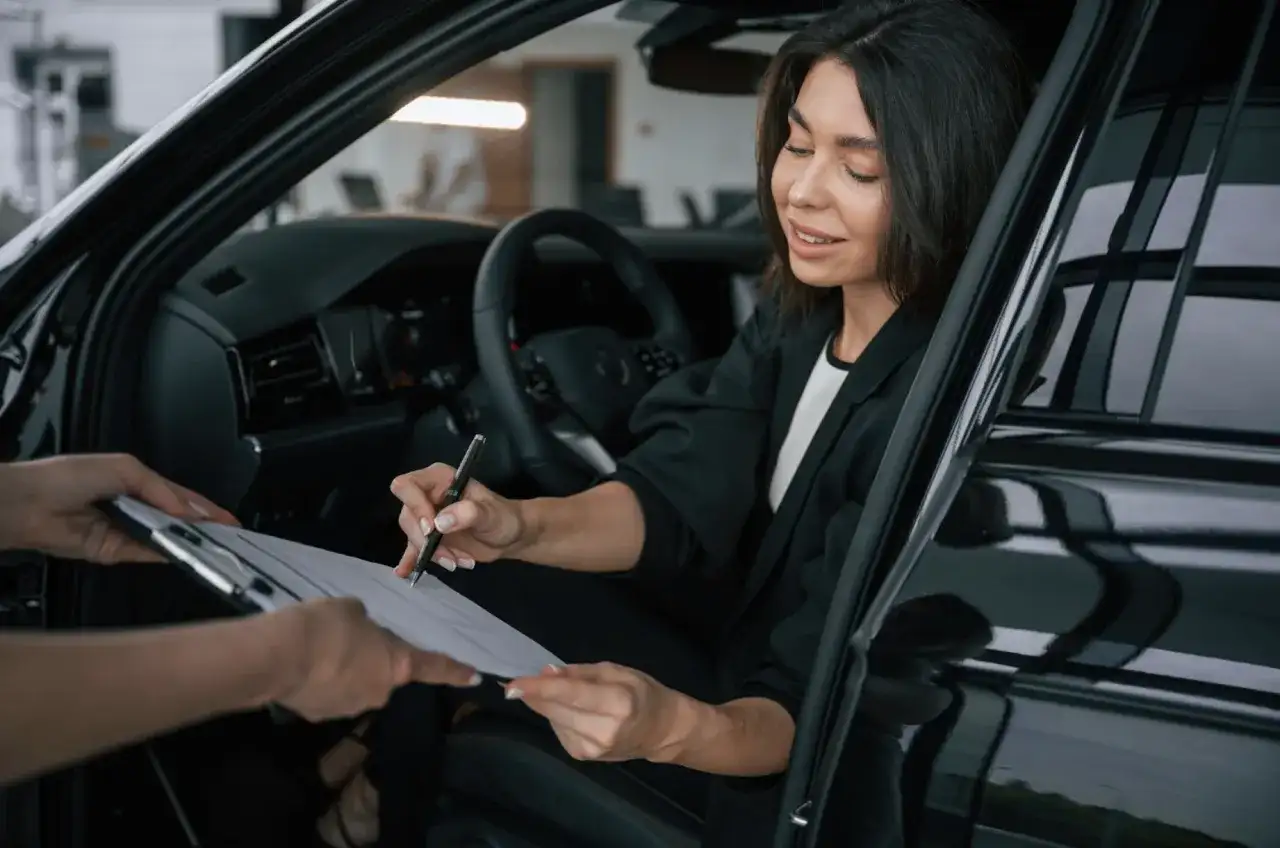 kobieta podpisująca umowę wynajmu samochodu