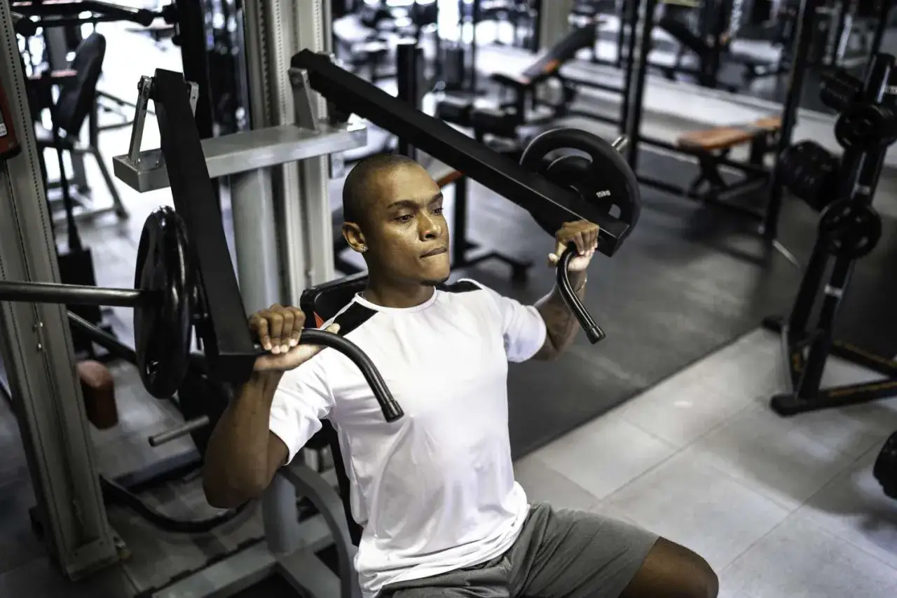 Man tränar bröstmusklerna på en flyes maskin i ett gym.